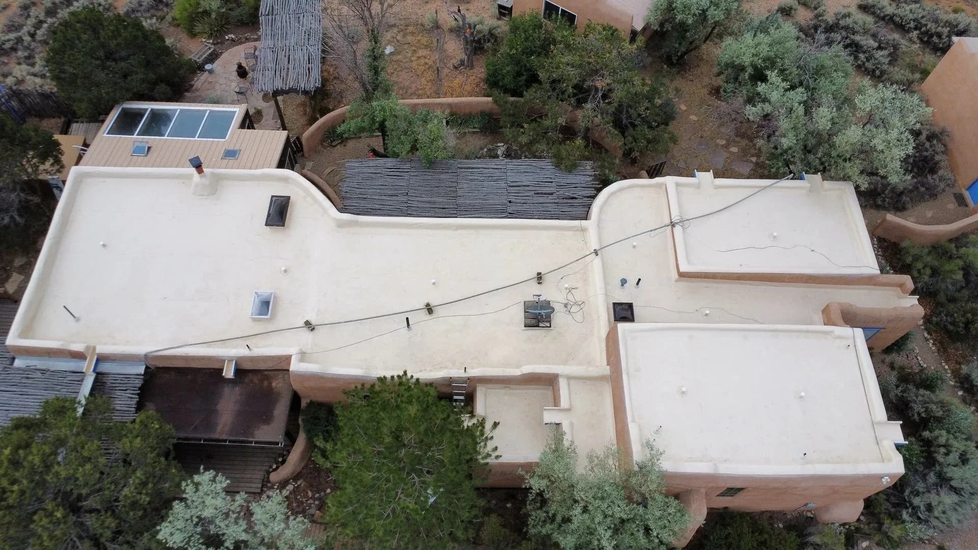 Flat TPO roof on an adobe-style home, aerial view